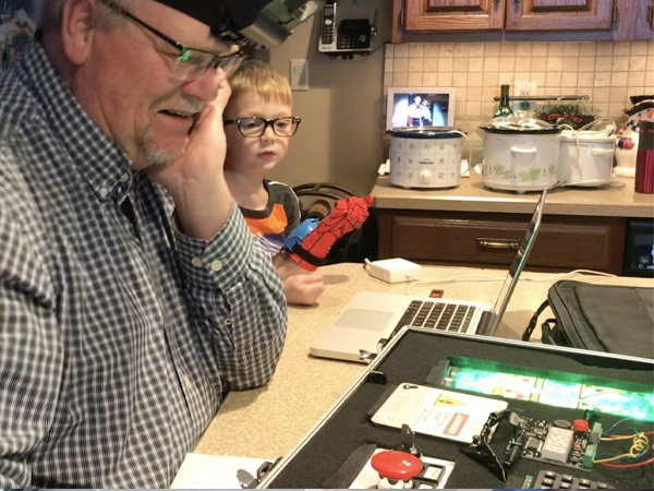 Jeff Forehand Escape Room - Father playing the Escape room game at a kitchen table - child looking over his shoulder
