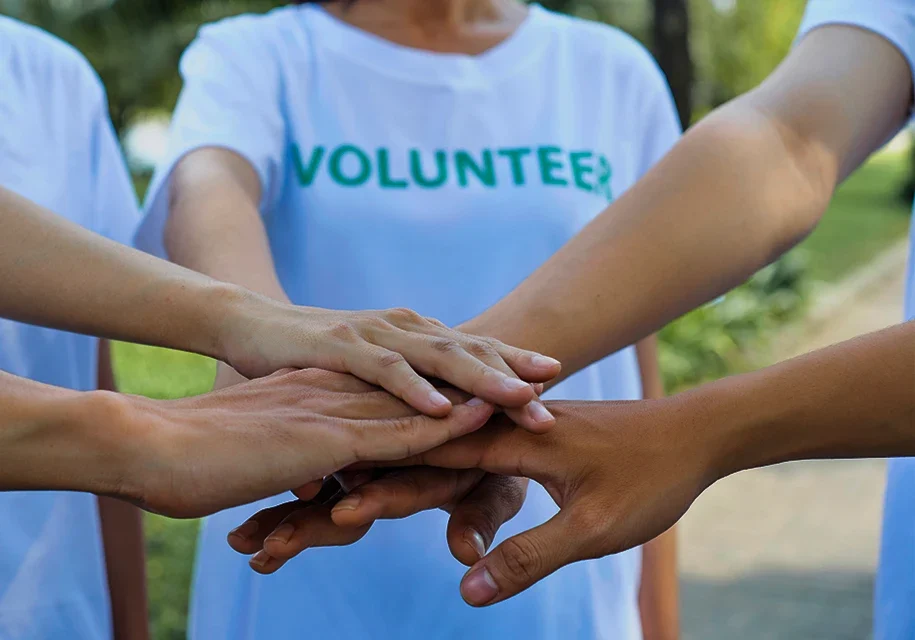 Volunteering Stock Photo With 5 People putting their hands in a circle